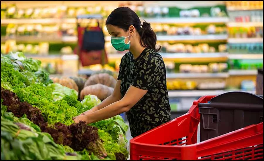 woman in the produce section at the grocery store