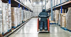 Warehouse worker operating pallet jack Warehouse worker operating pallet jack in cold storage logistics