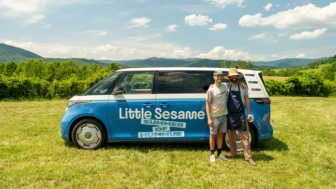 Co-founders Nick Wiseman, left, and Ronen Tenne posing outside in front of their Volkswagen with the "LIttle Sesame Summer of Hummus" wrapper.