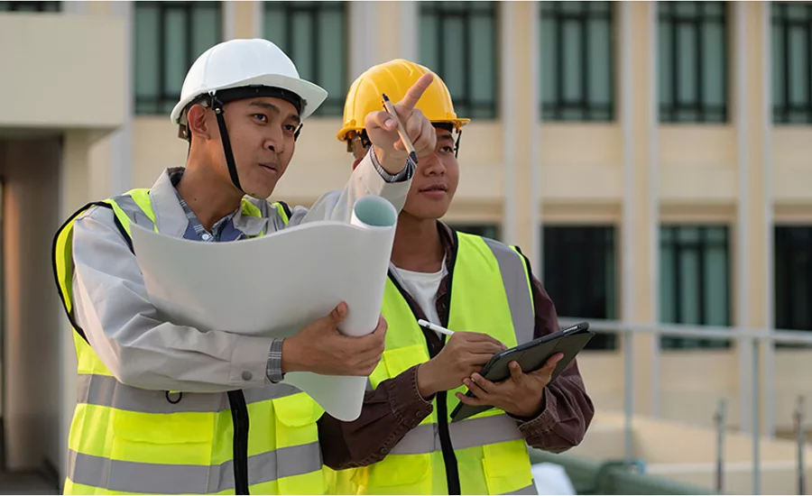 construction engineers discuss a blueprint