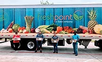 a truck and people holding produce a truck and people holding produce